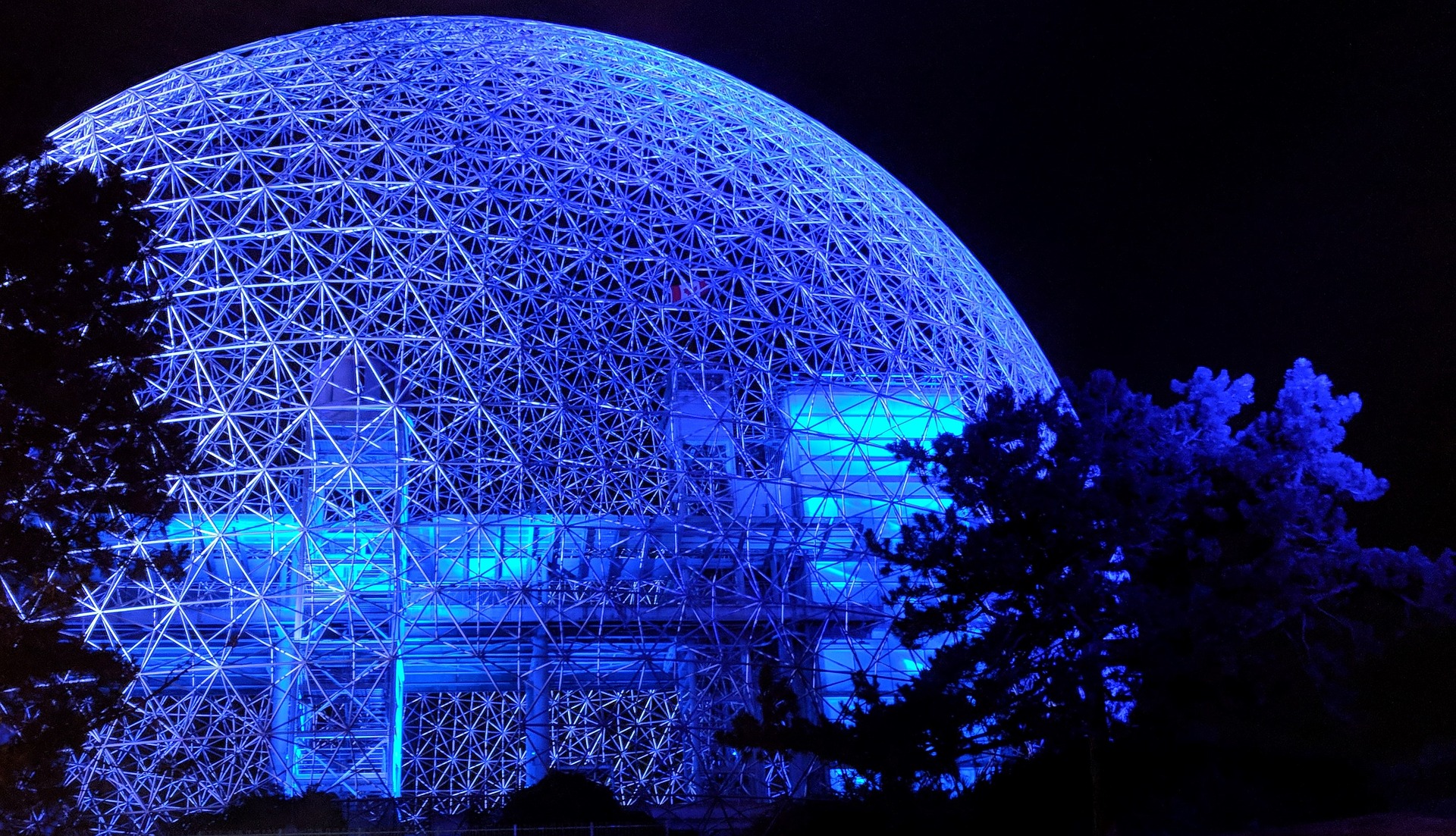 A dark blue geodesic dome at night